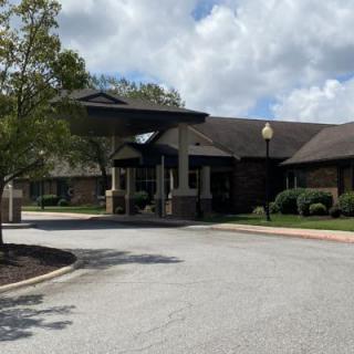 The exterior view of a building with a prominent entrance under a cloudy sky.