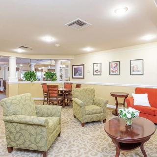 A cozy seating area with comfortable chairs and a table in a well-lit living room.