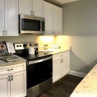 A modern kitchen with white cabinets and stainless steel appliances.