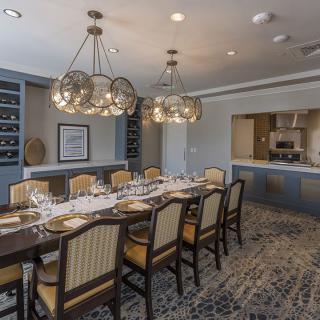 A beautifully decorated dining room with an elegant table setting and modern chandeliers.