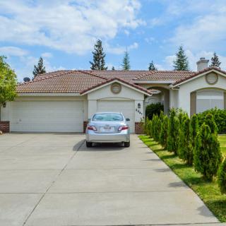 A suburban house with a driveway and car parked in front.