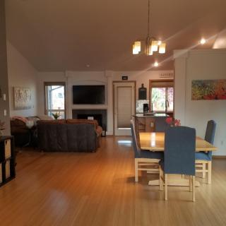 A modern open-plan living and dining area with wooden flooring and contemporary furniture.