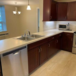 Modern kitchen with dark wood cabinets and stainless steel appliances.