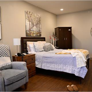 A cozy and modern bedroom featuring a comfortable bed, stylish armchair, and thoughtful decor.