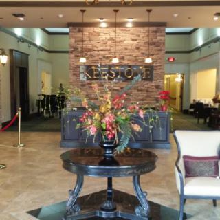 A hotel lobby area featuring a central table with a floral arrangement.