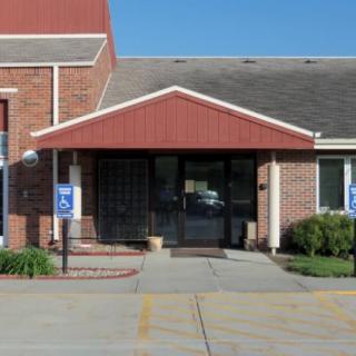 The entrance of a brick commercial building with a covered awning.