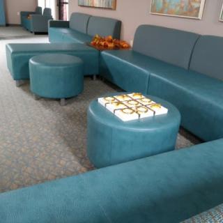 A modern living room setup featuring teal seating and ottomans.