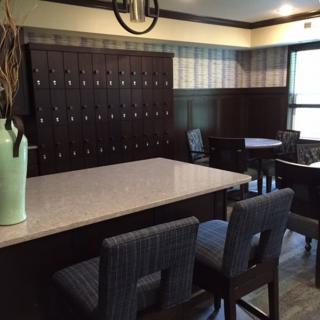 A modern interior space featuring tables, chairs, and lockers.