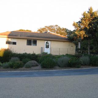 A suburban residential house with a garden at sunset.