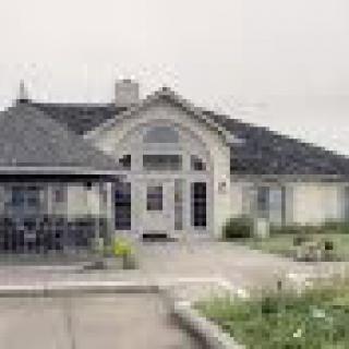 A residential house with a front garden and paved driveway.