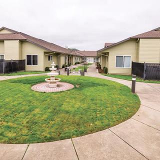 A serene courtyard with a central fountain surrounded by residential buildings.