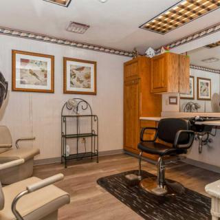 A cozy salon interior featuring a barber chair, mirror, and stylish decor.