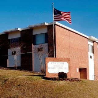 A brick building with an American flag flying in front.