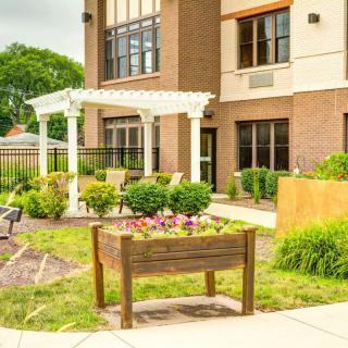 A well-maintained garden with a pergola outside a modern building.