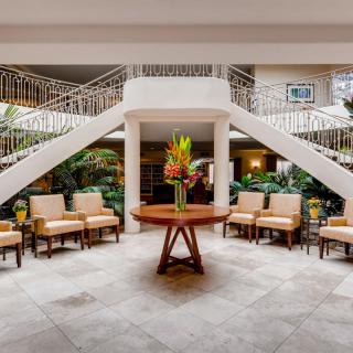 A spacious hotel lobby with elegant staircases and seating areas.