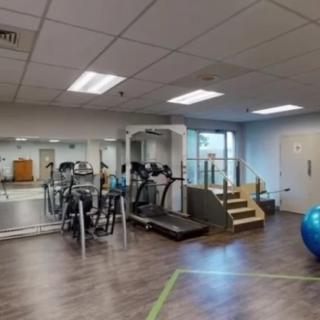 A modern gym with various fitness equipment including treadmills and exercise bikes.
