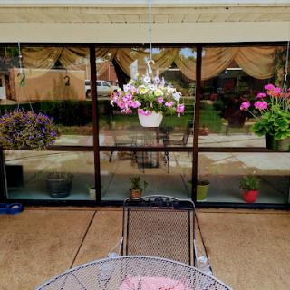 A picturesque outdoor patio with blooming flowers and a serene reflection.