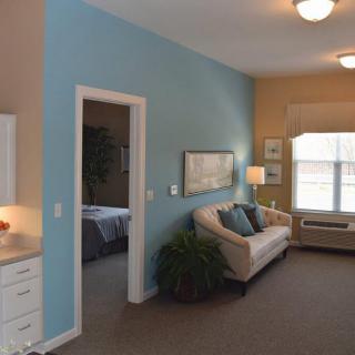A modern living room with a blue accent wall, comfortable sofa, and large window.