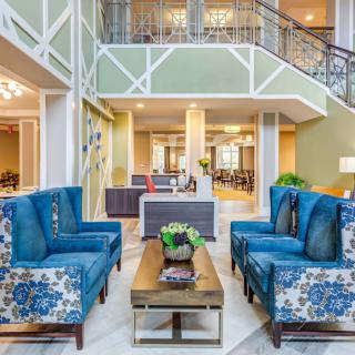 A modern and spacious lobby featuring elegant blue sofas and a stylish coffee table.