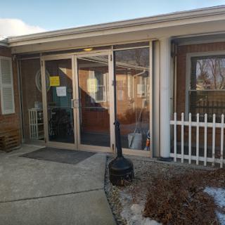 The entrance to a residential building featuring glass doors and a welcoming front porch.
