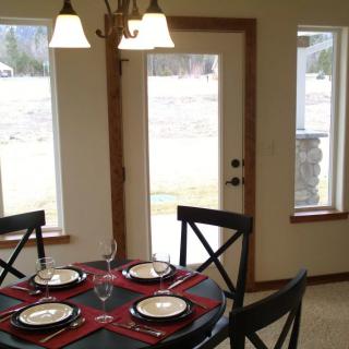A cozy dining area with a neatly set table for four, featuring elegant place settings and a warm ambiance.