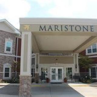 The entrance of the Maristone building, featuring a covered driveway and brick architecture.