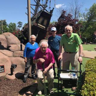 A group of seniors enjoying a sunny day outdoors.