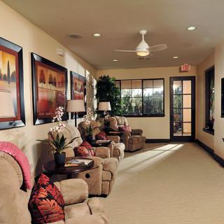 A cozy living room with comfortable seating and decorative paintings on the walls.