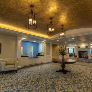 A luxurious lobby featuring elegant chandeliers, a reception desk, and stylish furniture.