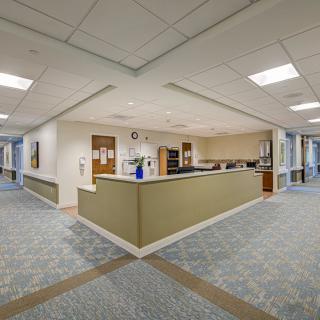A hospital reception area with a central desk and adjacent corridors.