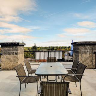 An outdoor patio with a table and chairs set against a scenic backdrop.