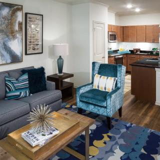 Modern living room with an open kitchen concept, featuring comfortable seating and stylish decor.