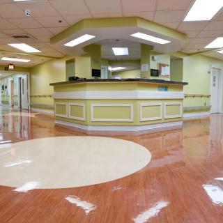 A clean and modern hospital reception area with a central desk and polished flooring.