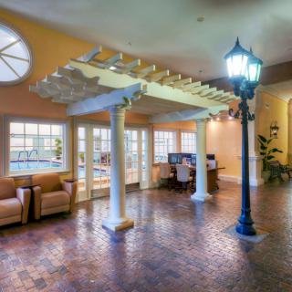 A spacious lobby area with comfortable seating, decorative columns, and a lamppost.