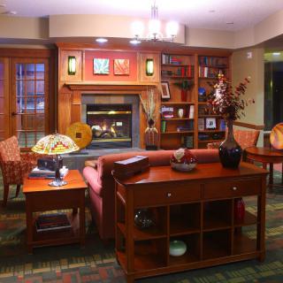 A cozy living room with a fireplace and wood furnishings.