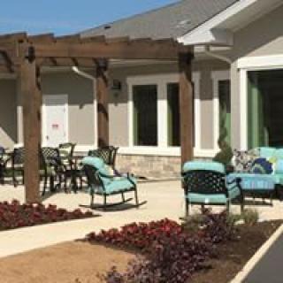 A cozy outdoor patio area with comfortable seating and a wooden pergola.