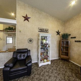 A cozy living room with a leather chair, decorative stars on the wall, and a display cabinet filled with various items.