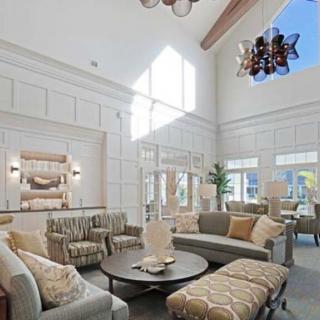 A spacious and well-lit living room featuring modern furniture and high ceilings.