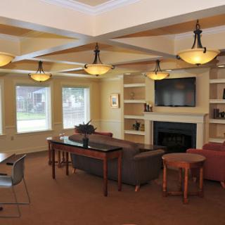 A cozy and modern living room featuring ample seating, a fireplace, and natural light from large windows.
