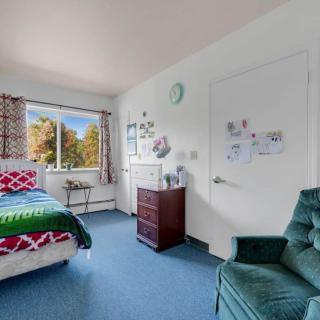 A cozy bedroom with a large window and comfortable furniture.