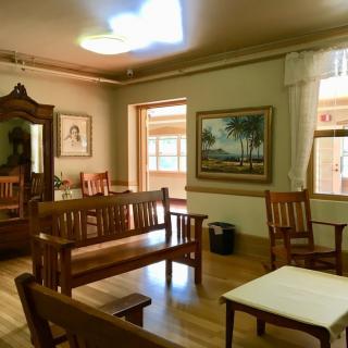 A cozy living room with wooden benches, artwork on the walls, and ample natural light.