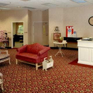 A cozy lobby area with vintage-style furniture and a patterned carpet.