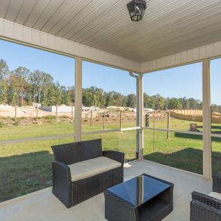 A cozy patio with modern outdoor furniture overlooking a spacious backyard.