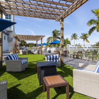 A sunny outdoor patio featuring comfortable seating and palm trees.