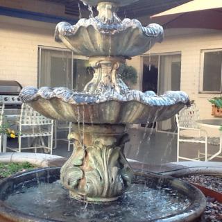 A multi-tiered garden fountain in a courtyard setting.