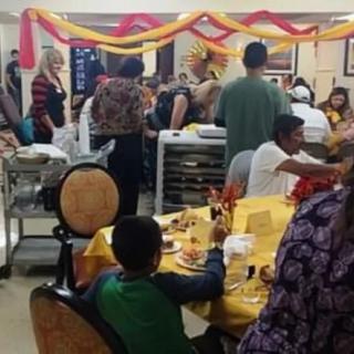 A lively indoor celebration with tables set for a party and people enjoying the festive atmosphere.