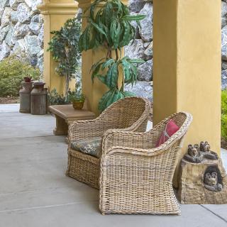 A cozy outdoor patio area with wicker chairs and plants.