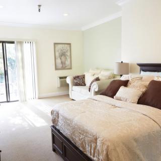 A bright and cozy bedroom with a large bed and sofa.