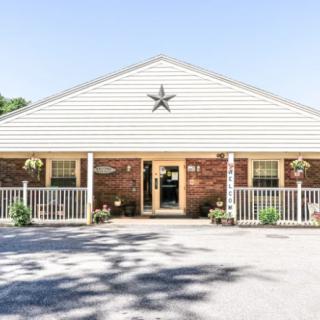 A small, single-story brick building with a star decoration above the entrance and a white railing on the porch.