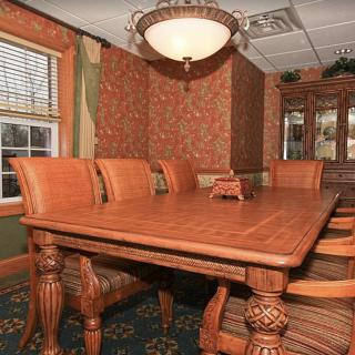 A cozy dining room featuring a large wooden table and elegant decor.